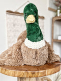 Plush duck toy on a wooden surface with a blurred background